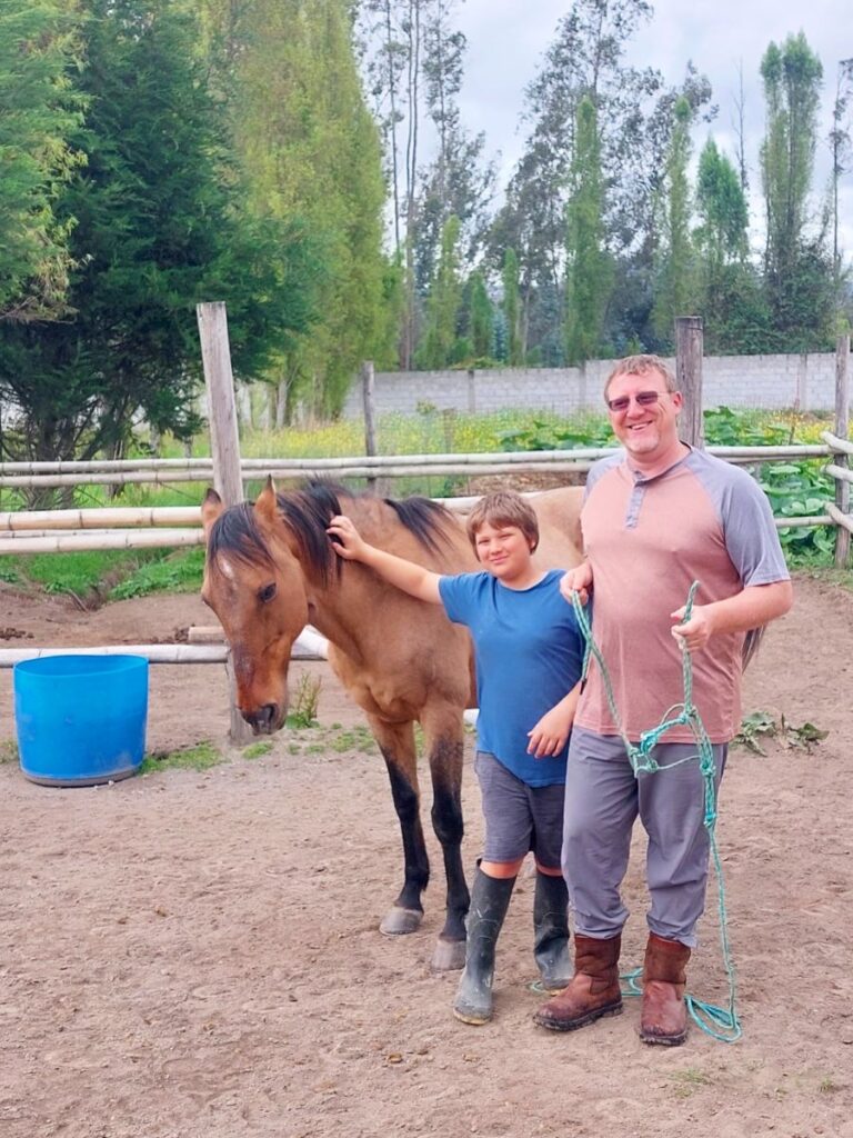 David and Little Man standing with a brown horse that we house sat in Ecuador.