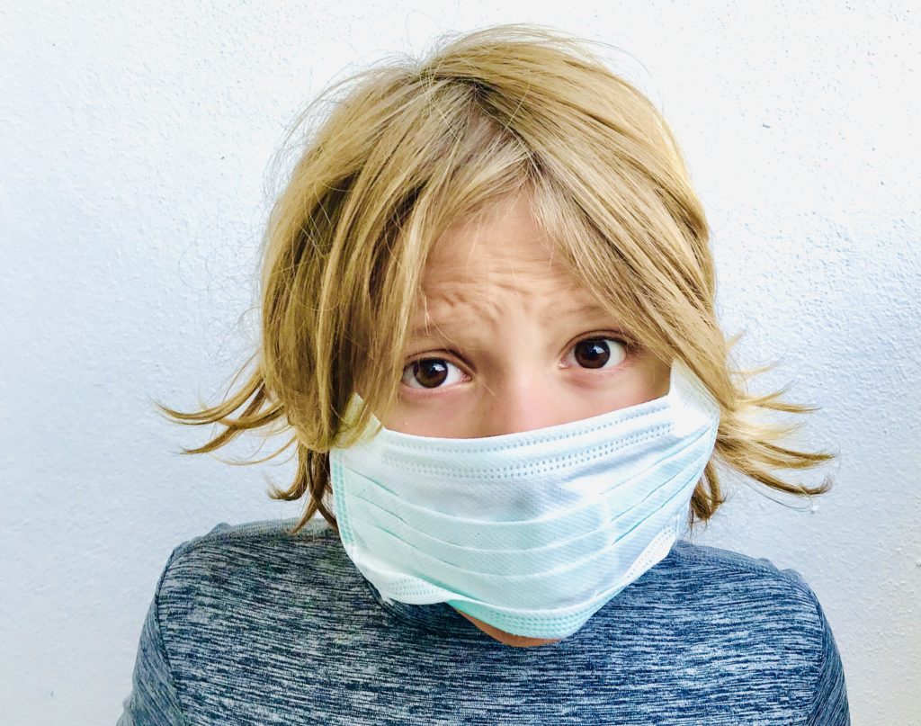 Coronavirus face mask on a worried kid