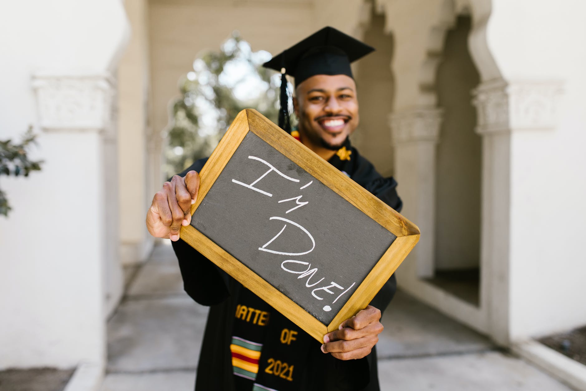 man in black academic dress holding brown wooden frame
private online homeschool