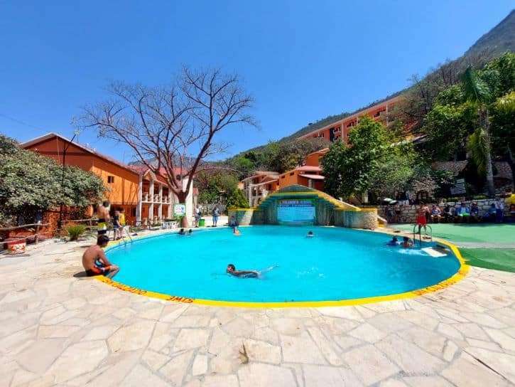The smaller round pool with a small footbridge over the far side near Hotel El Paraiso at Grutas Tolantongo Hot Springs. Photo was taken during the day.