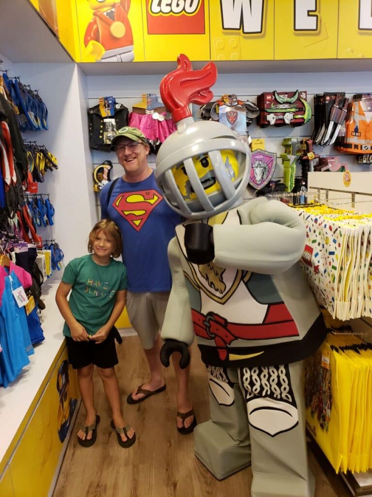 David and Little Man posing with the Lego Knight character in a shop at Legoland Malaysia.
