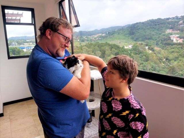 David and Little Man petting a cat at our housesit in Guatemala.