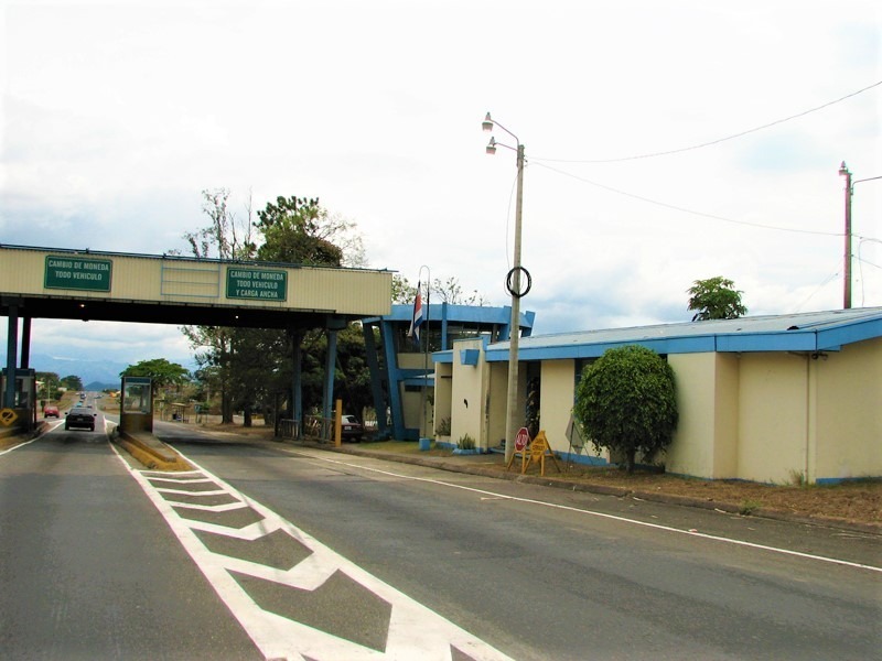 Toll booth in the daytime with Spanish language on the signs.