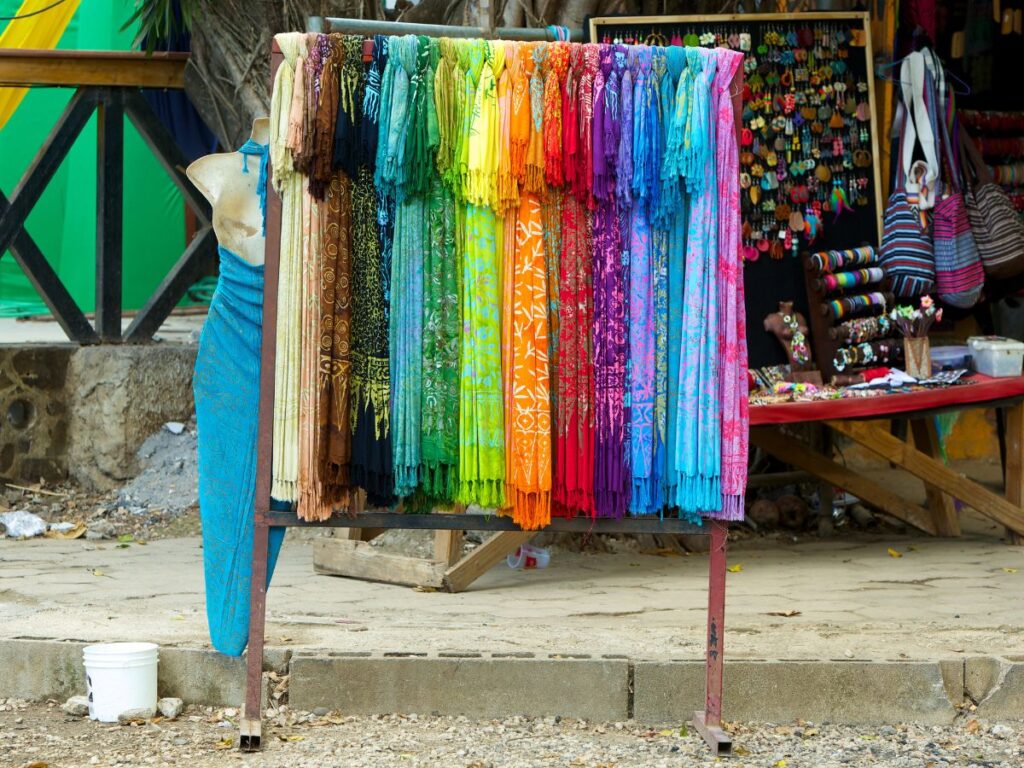 Colorful dresses organized in a rainbow on display outside a shop in Costa Rica.