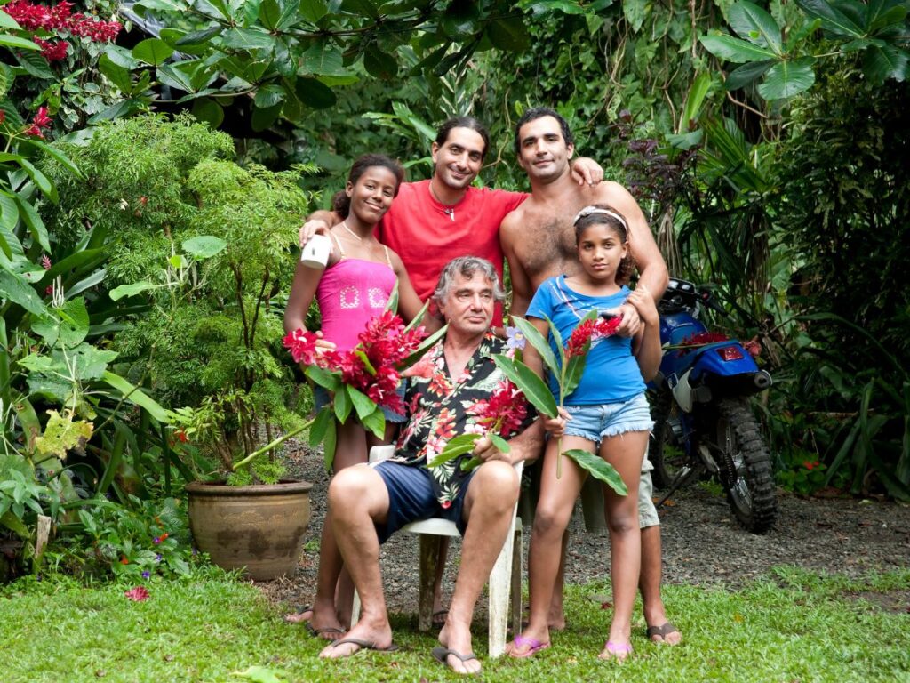 Three Costa Rican men and two younger girls posing together for a photo in the jungle.