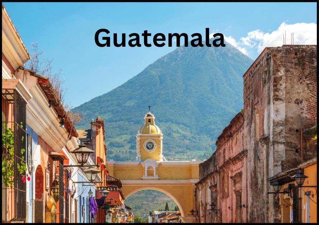 Famous yellow arch in Antigua Guatemala with a volcano behind it and "Guatemala" above it.