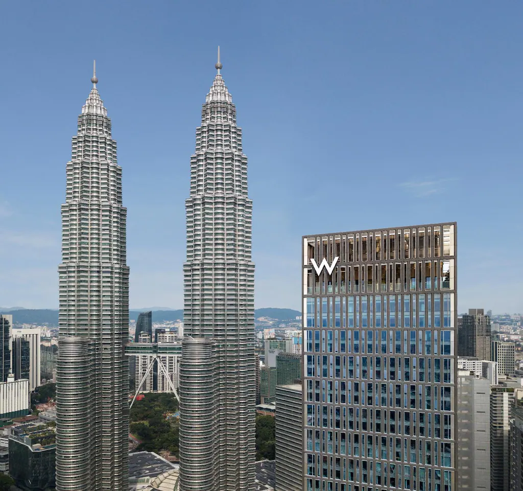 Daytime exterior view of the W Hotel Kuala Lumpur next to the Petronas Twin Towers