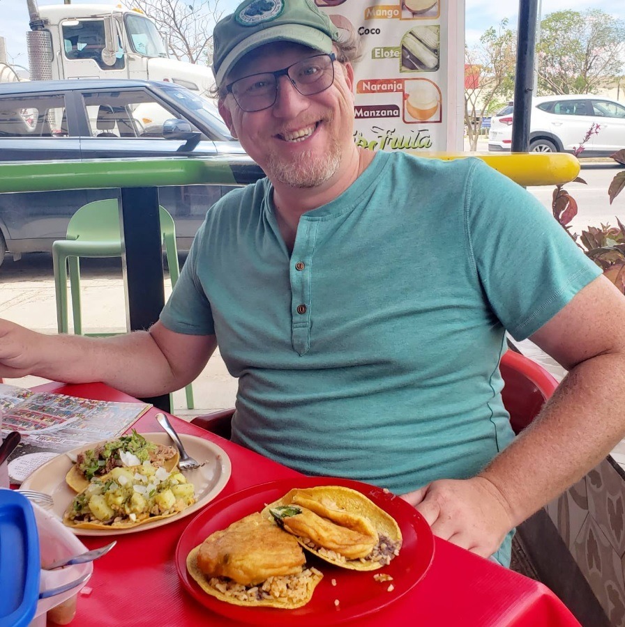 Man similing while eating tacos at El Gran Taco in Playa del Carmen.