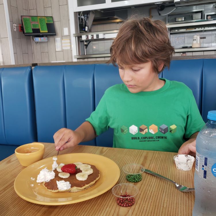 Kid decorating a pancake at IHOP in Playa del Carmen.