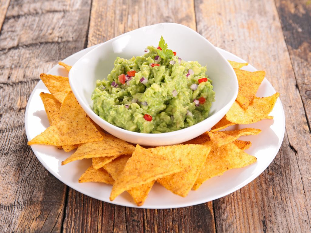 Chips and guacamole on a wooden table