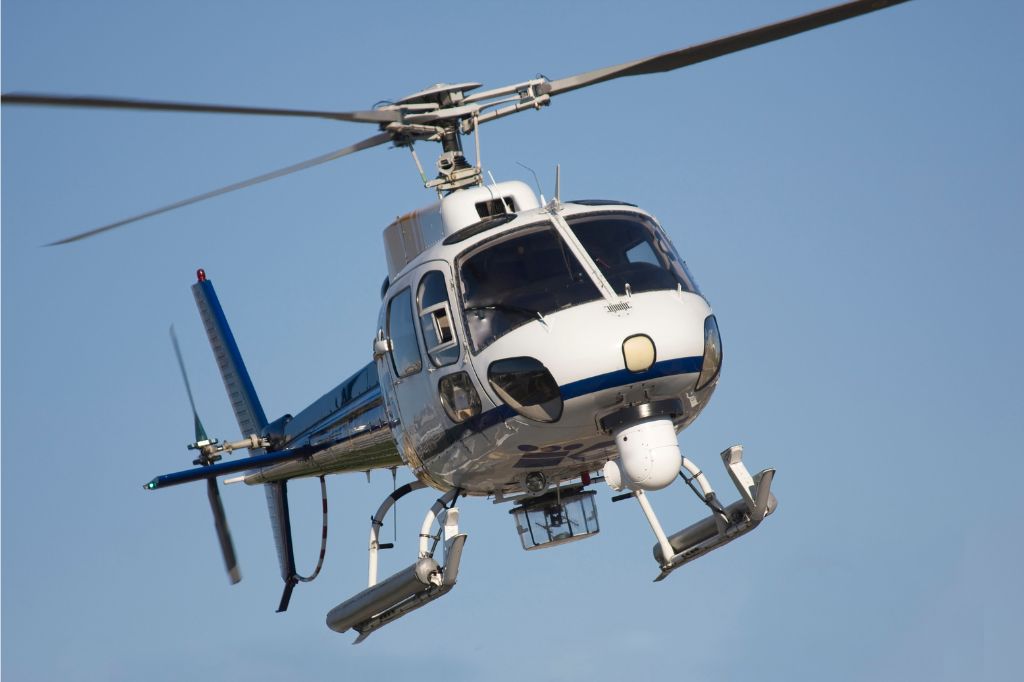 Blue and white helicopter flying in the air.