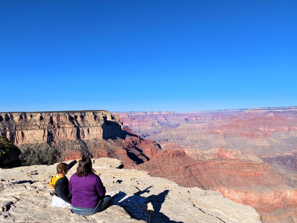 Mother and son sitting sitting at the Grand Canyon South Rim