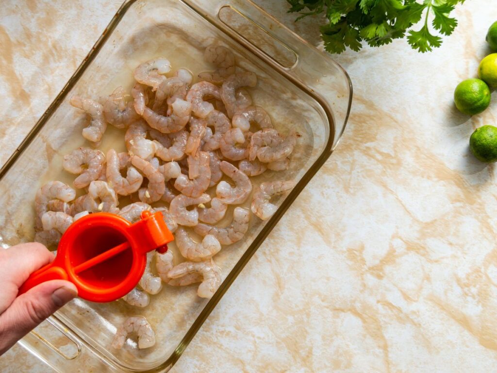 squeezing lime over shrimp to make ceviche
