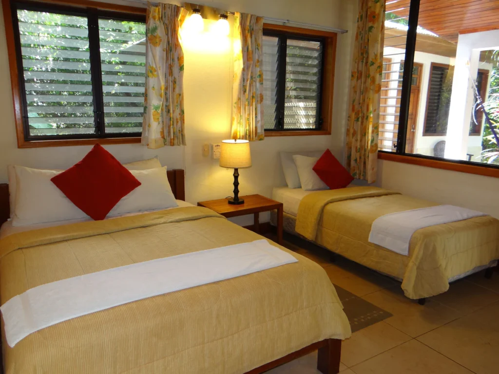 Guest room at Hotel Jaguar Inn Tikal with a double bed and single bed.