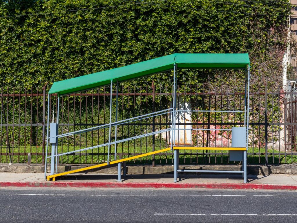 Raised bus stop with a small roof and a ramp up to it in Guatemala City.