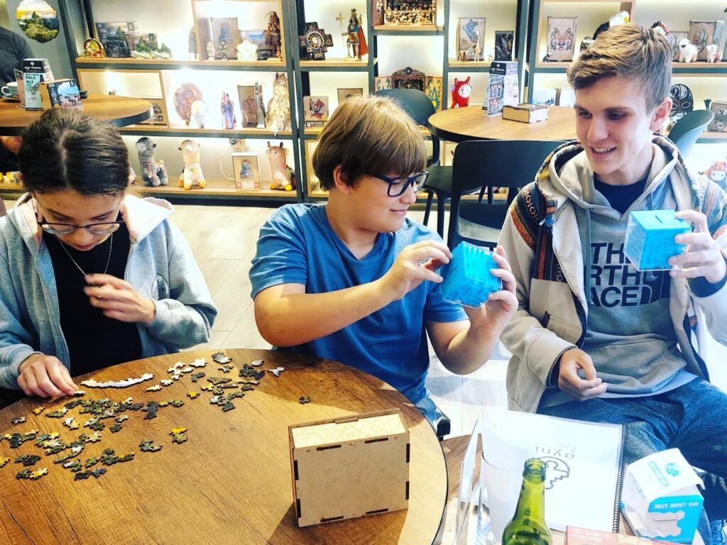 Little Man with friends at a puzzle cafe in Cusco Peru
