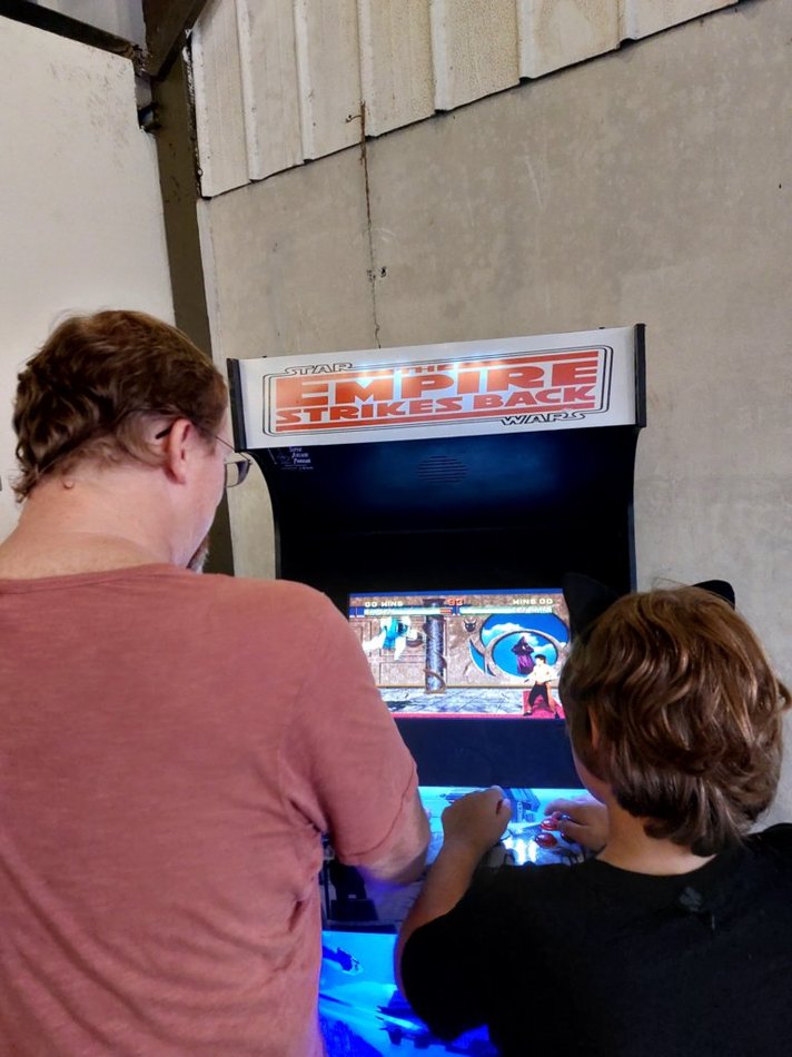 David and Little Man playing an old school arcade game. It's a great Western Cook County and Oak Park Kids activity!