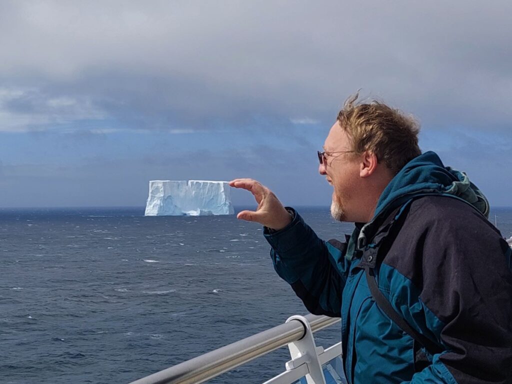 David pretending to pick up an ice berg in Antarctica