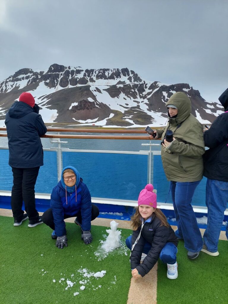 Little Man and a friend with a snowman they built on deck after a snowstorm from Iceberg A23a during our Antarctica cruise.