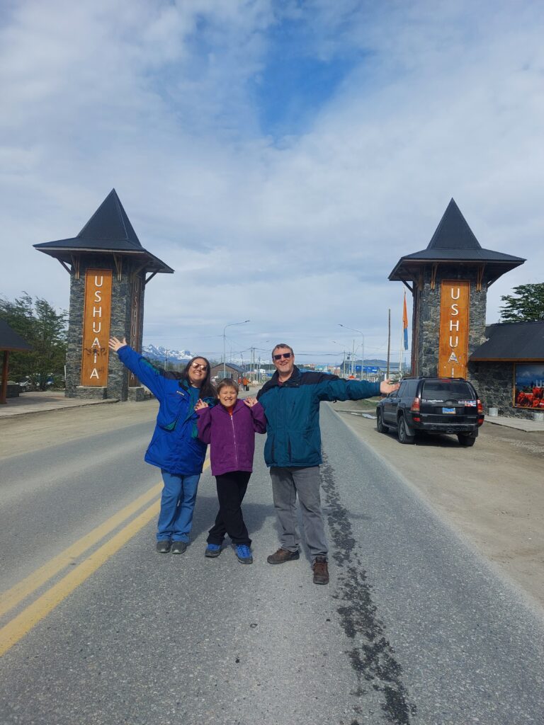 Family photo at the end of the world in Ushuaia Argentina with the car we drove to get there.