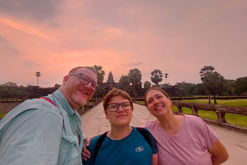 Our family at Angkor Wat at sunrise in Cambodia, the cheapest country for nomads with kids.