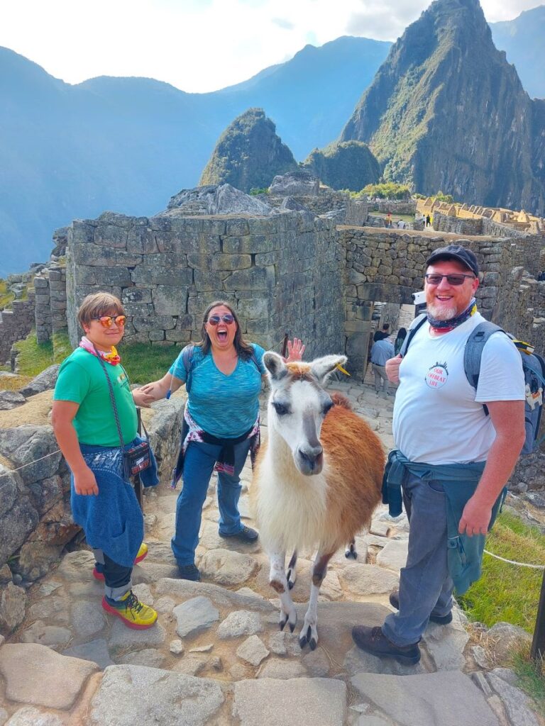Our family taking a photo at Machu Picchu in Peru while getting photobombed by a wild llama.