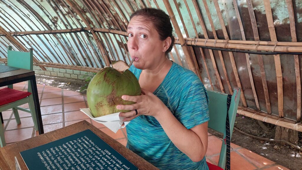 Brodi drinking a giant, fresh coconut in Cambodia