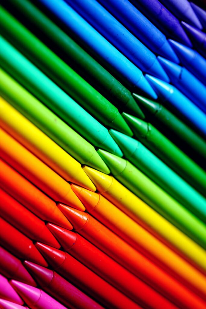 Flatlay of vivid colored crayons showcasing a spectrum of hues in a creative alignment.